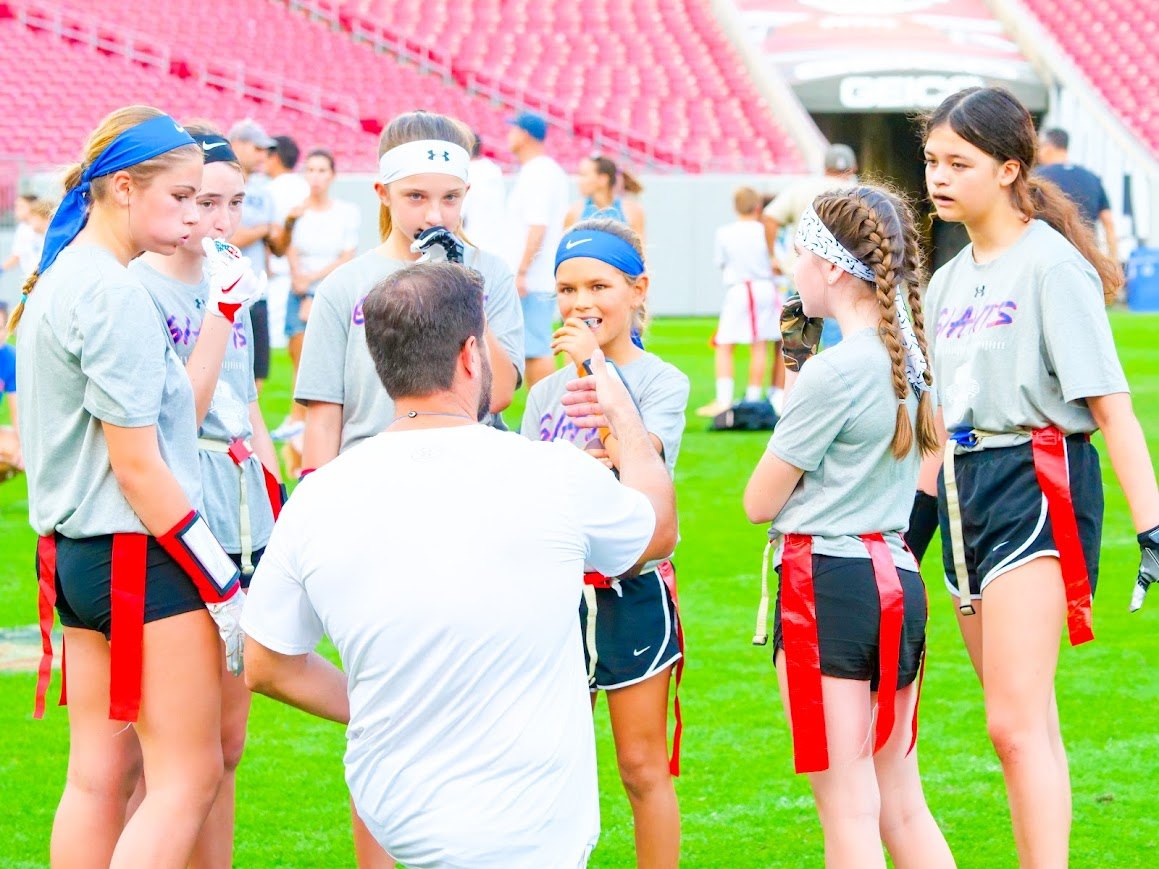 Girls flag football coaching huddle